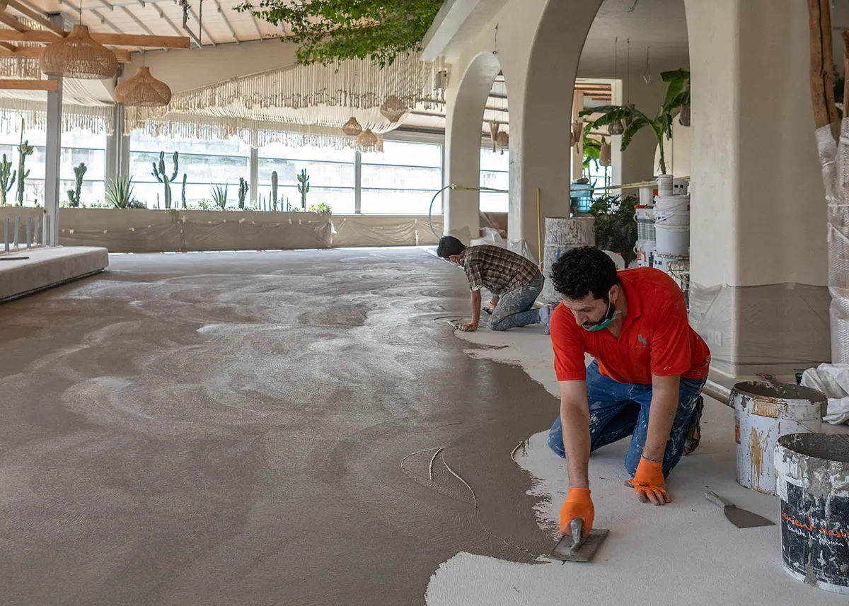 Workers applying microcement flooring